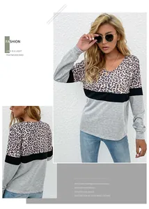 Detail of V-neck long sleeve top with leopard print stitching and color block design