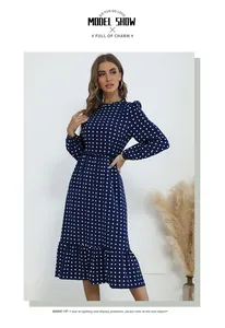 Détails d'une robe mi-longue bleu marine à pois avec col à volants et taille plissée