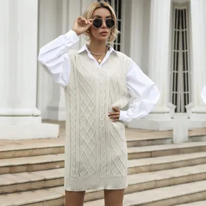 Women's cream cable knit vest dress with V-neck, layered over a white shirt in an elegant style
