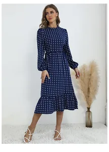 Détail d'une robe midi à pois bleu marine avec col à volants et manches longues