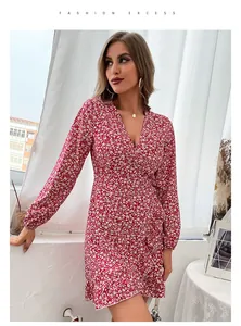 Detail showing the red floral print fabric, V-neck wrap design and ruffle hem dress