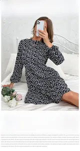 Detail of navy floral dress featuring a ruffled high neck and long elastic puff sleeves