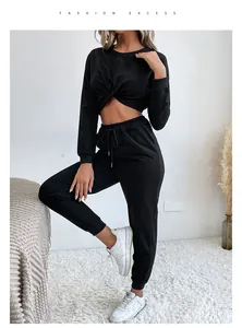 Détail d'un ensemble détente noir deux pièces avec haut court noué et pantalon de jogging