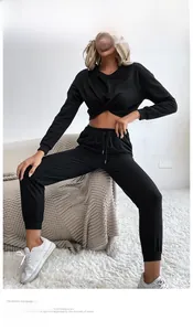 Gros plan d'un ensemble de sport noir avec haut court noué et jogging taille haute