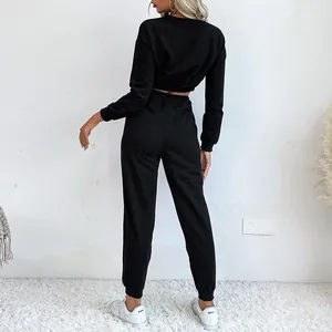 Vue arrière d'un survêtement noir deux pièces pour femme avec sweat court et jogging