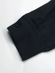 Detailed macro view of long sleeve cuff with single black button on textured fabric