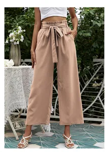 Détail du pantalon taille haute à jambes larges avec nœud et taille plissée