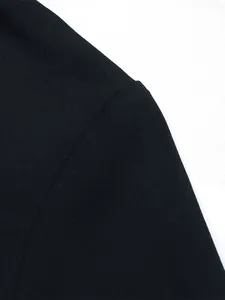 Detail view of the fine textured fabric and clean shoulder seam on the black dress
