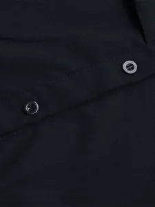 Detail shot of the dark fabric texture and black four-hole buttons on the shirt dress