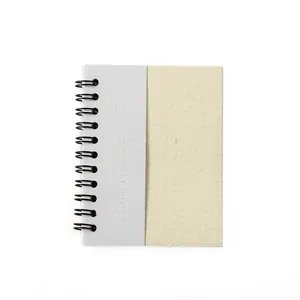 Minimalist spiral notebook with textured beige and grey cover and embossed lettering