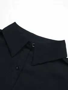 Close-up of lapel collar and buttons on a slim black long-sleeved shirt dress