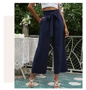 Détail du pantalon large bleu marine à taille haute avec une ceinture nouée élégante