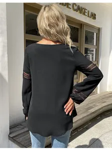 Dettaglio di camicia nera a maniche lunghe con inserti in pizzo traforato sul retro