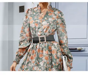 Détail de robe fleurie montrant un col en V à volants vintage et boutons en bois