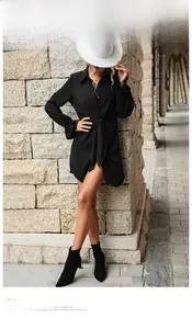 Détail de la robe chemise noire à manches longues avec taille nouée et col classique