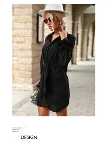 Détail de robe chemise noire à manches longues avec ceinture à la taille et boutons