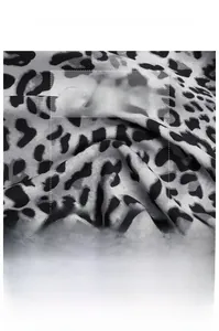Detailed macro view of soft leopard print fabric texture on a cinched waist shirt dress