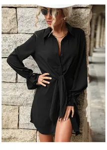 Détail d'une robe chemise noire à manches longues avec col à revers et ceinture