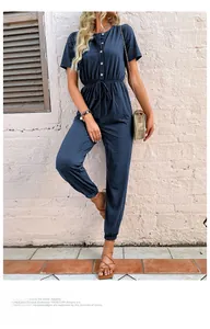 Dettaglio di una tuta blu navy a maniche corte con coulisse in vita e chiusura a bottoni