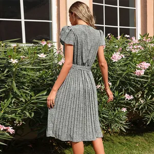 Detail of floral pleated hem and tie waist belt on a black V-neck midi dress