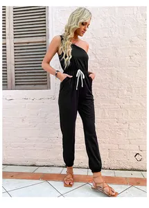 Detail eines schwarzen One-Shoulder-Jumpsuits mit Kordelzug an der Taille und Seitentaschen