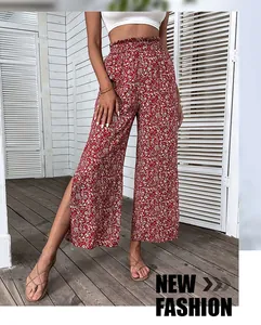 Detail of red floral high-waist wide-leg pants with elastic waist and side split hem