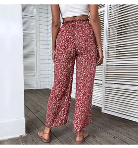 Detail view of red floral high-waisted wide leg pants with elastic smocked waist design