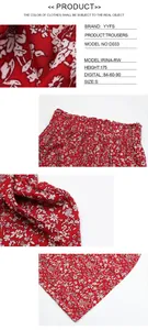 Detail view of red floral high-waisted wide-leg pants showing fabric texture and elastic waist