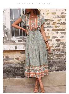 Detail of bohemian V-neck dress featuring green paisley floral print and button-down front