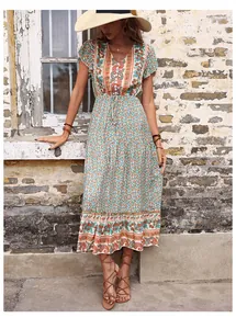 Detailed view of bohemian floral print on a green V-neck dress with ruffle sleeves