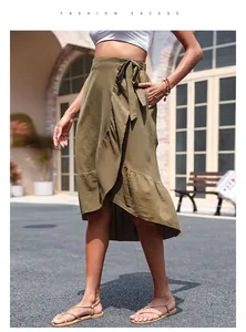 Detail of green cotton linen wrap skirt with ruffled hem and waist tie closure