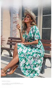 Détail d'une robe longue d'été verte à fleurs avec col en V et manches courtes ajustées