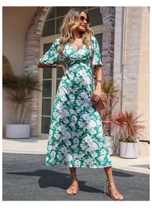 Détail d'une robe midi fleurie verte avec décolleté en V plongeant et nœud frontal