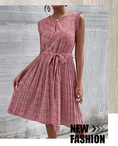 Détail de robe fleurie rouge avec décolleté ajouré et nœud papillon à la taille