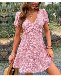 Dettaglio di un vestito floreale rosa con maniche a sbuffo e balze in chiffon in giardino