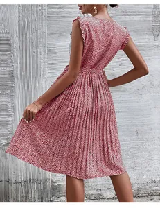 Détail d'une robe plissée rouge à fleurs avec manches volantées et texture mousseline légère