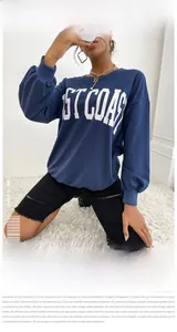 Detail of West Coast letter print on navy blue crewneck sweatshirt with soft fabric texture