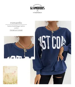 Detailed view of golden chain necklace with letter B pendant on a navy sweatshirt