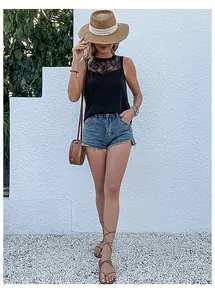 Dettaglio di un top nero senza maniche con pizzo per un look estivo con shorts in jeans