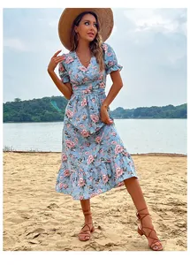 Détail du décolleté en V et manches bouffantes sur une robe d'été fleurie bleu clair