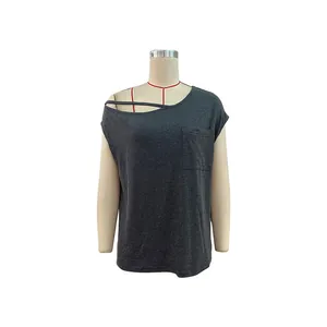 Detailed view of asymmetric cold shoulder neckline and front pocket on dark gray top