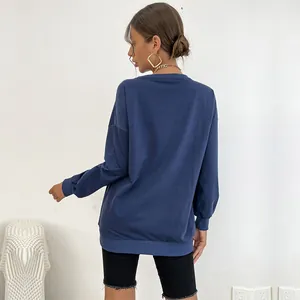 Back view of a woman wearing a dark blue crewneck sweatshirt and black cycling shorts