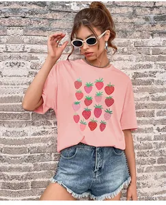 Detailansicht eines rosa T-Shirts mit Erdbeermotiv und ausgefransten Jeans-Shorts