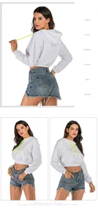 Detail of white cropped hoodie with yellow drawstrings and raw edge denim shorts