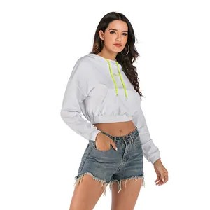 White cropped hoodie with neon drawstring and Hey! print styled with denim shorts