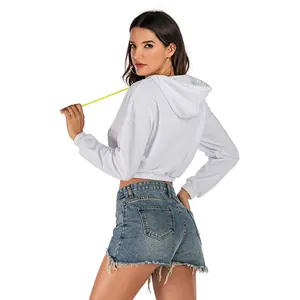 White cropped hoodie with neon drawstring and frayed blue denim shorts on model