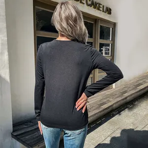 Women's black long sleeve knit top with leopard print stitching back view in sunlight