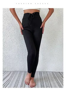 Détail du legging noir taille haute avec des lacets croisés décoratifs à la taille