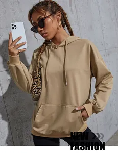 Detail of khaki oversized hoodie featuring a kangaroo pocket, drawstrings, and ribbed cuffs