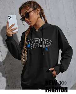 Detail of black oversize hoodie featuring blue butterfly and DRIP lettering graphic